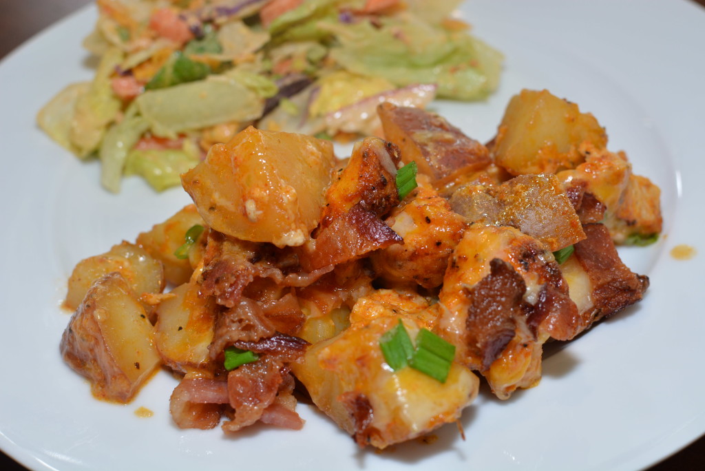 a scoop of loaded chicken and potato casserole on a plate with a side salad