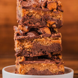pieces of chocolate peanut butter brownies stacked on a plate.