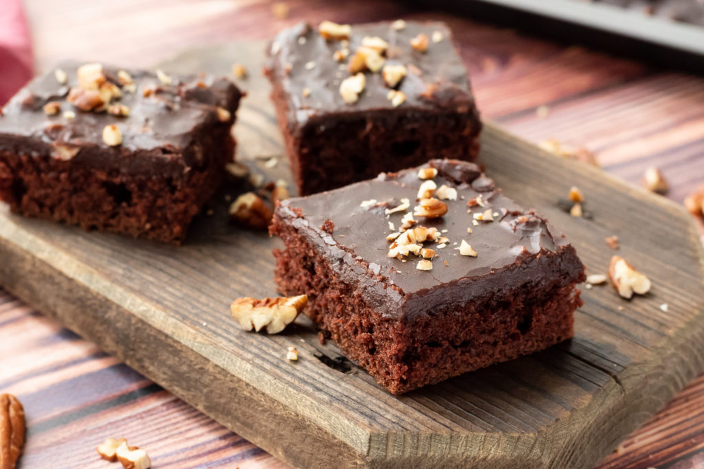 pieces of moist chocolate cake with a chocolate frosting on a serving platter