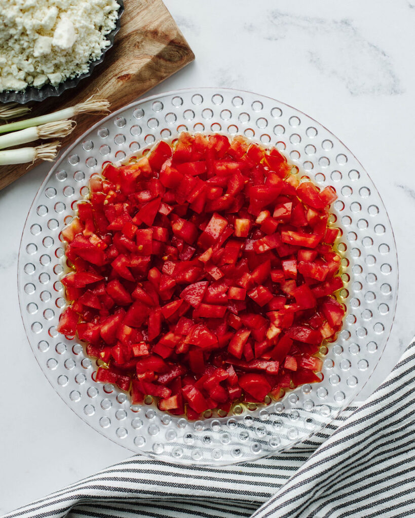 diced roma tomatoes in a glass bowl.