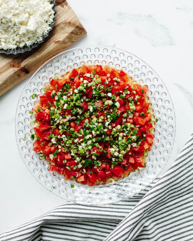 diced tomatoes and green onions in a glass bowl.
