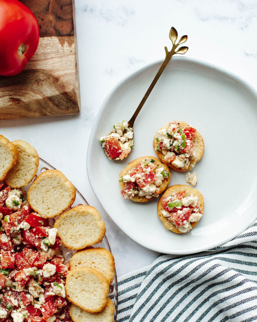 a cheesy tomato dip with baguette on a plate.