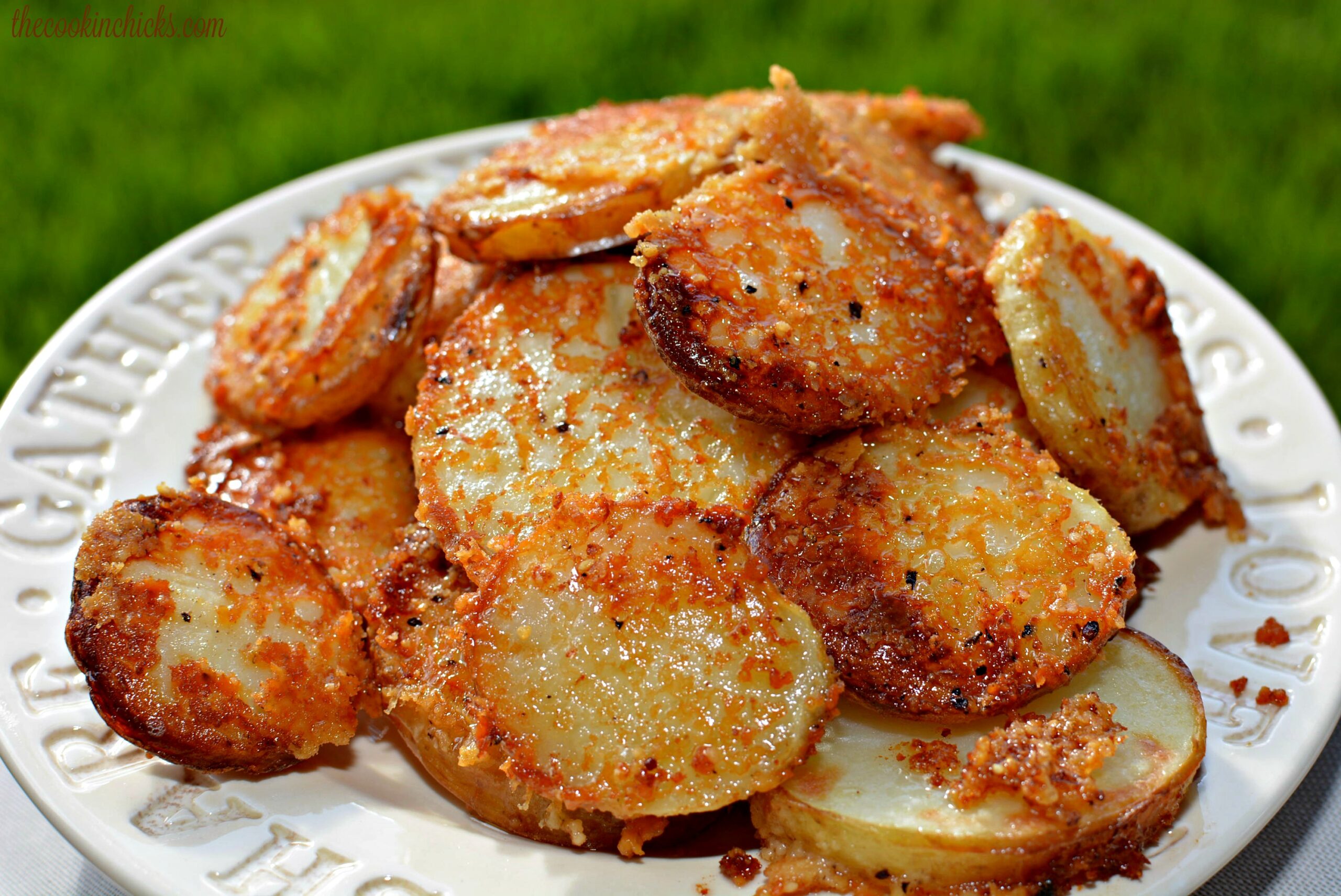 crispy potatoes coated in Parmesan and served on a plate.