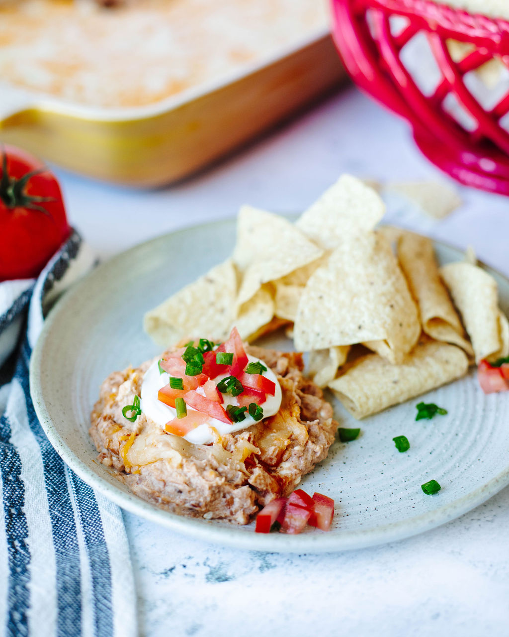 Texas Trash Dip on a white plate with tortilla chips.