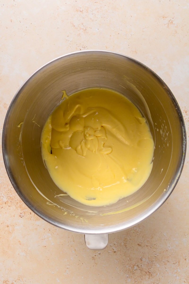 Creamy banana pudding mixture being folded with whipped topping in a mixing bowl.