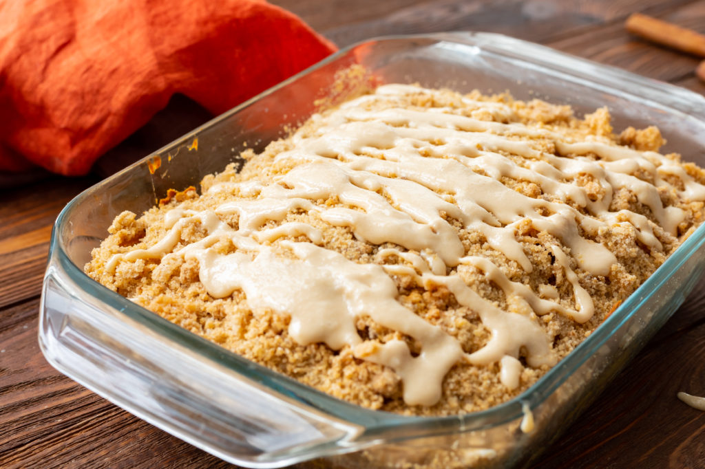 moist pumpkin cake with a streusel topping and powdered sugar glaze