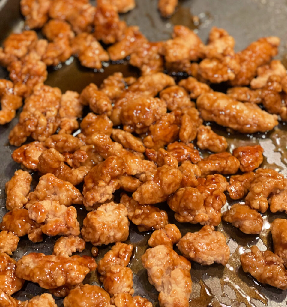 a tangy sweet sauce with orange zest coated fried chicken pieces