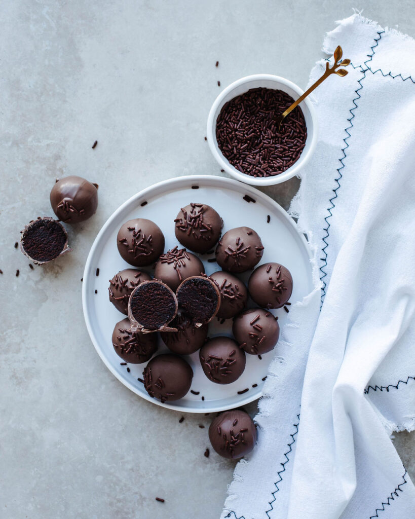 a white plate with Chocolate Cake Balls stacked.