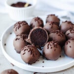 a sliced dessert ball with sprinkles on a white plate.