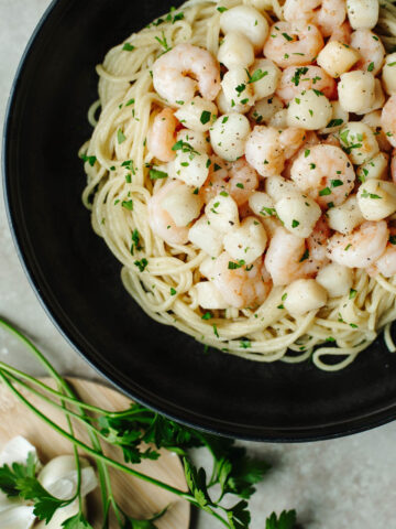 a seafood dinner made with three ingredients over a bed of pasta.