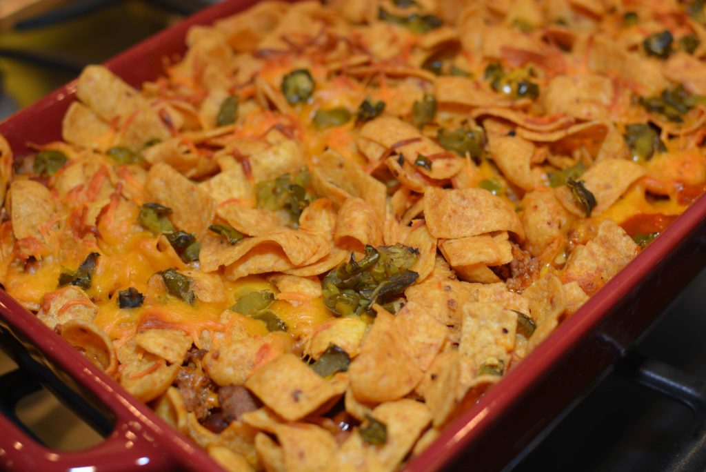 frito corn chips over taco seasoned beef chili, cheese, and peppers