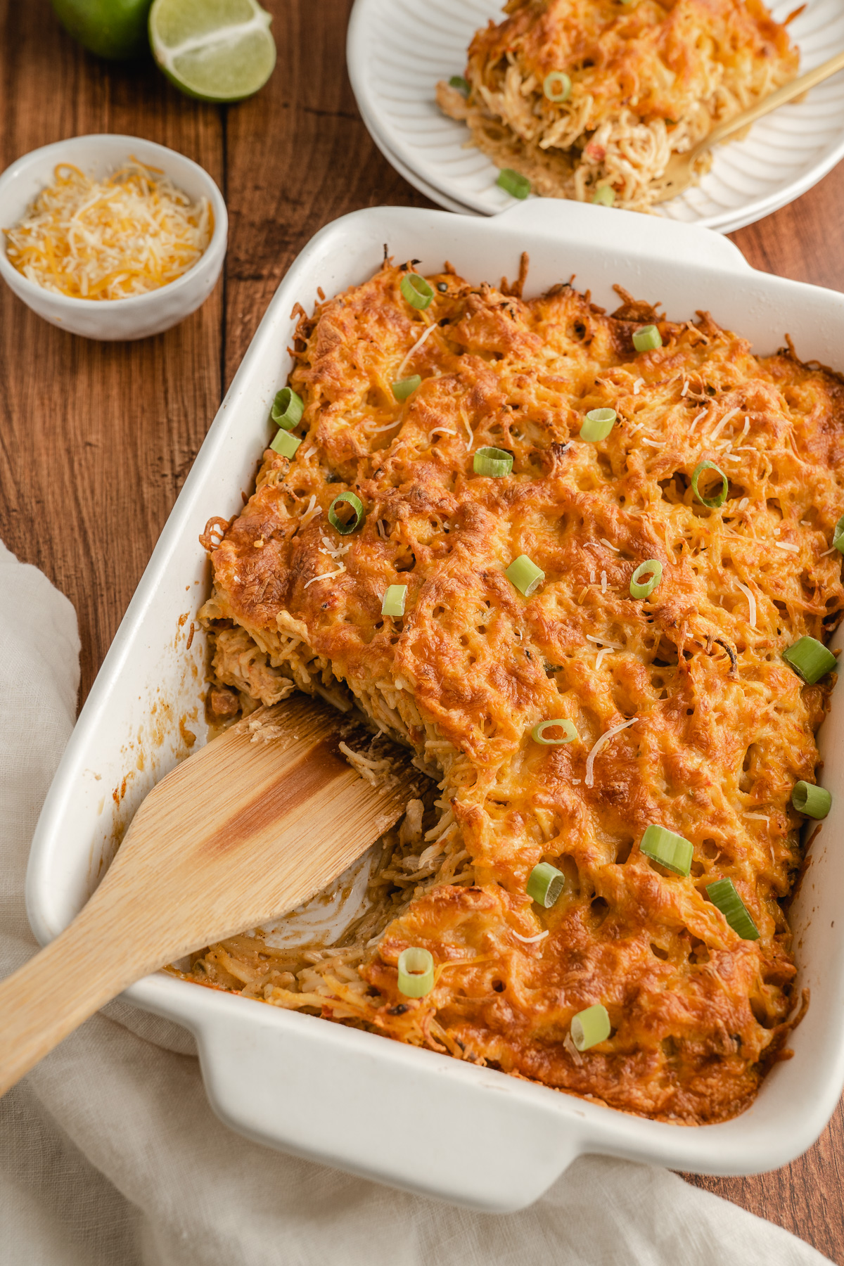 mexican cheesy chicken spaghetti in a white casserole pan.