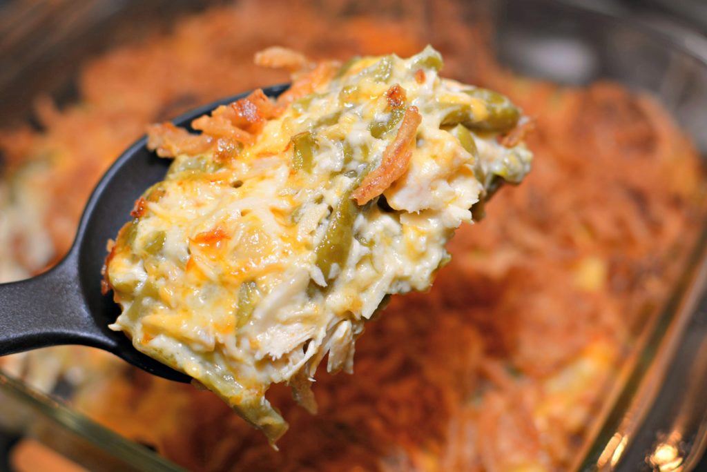 creamy chicken casserole with almonds, onions, and cheese throughout
