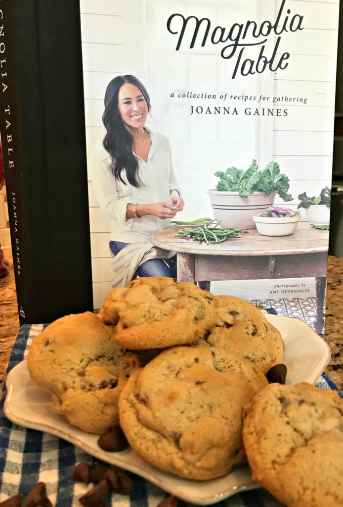 Fresh baked chocolate chip cookies staged in front of a cookbook