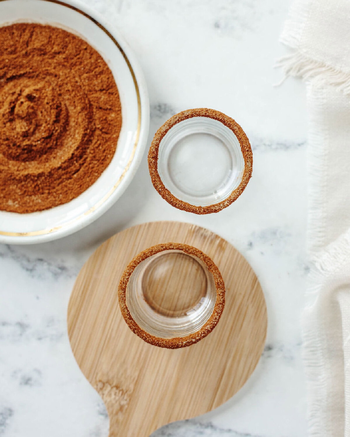 cinnamon and sugar rimming two shot glasses.