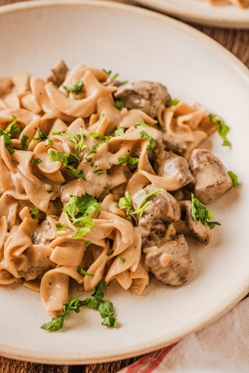 beef and noodles served on a white plate.