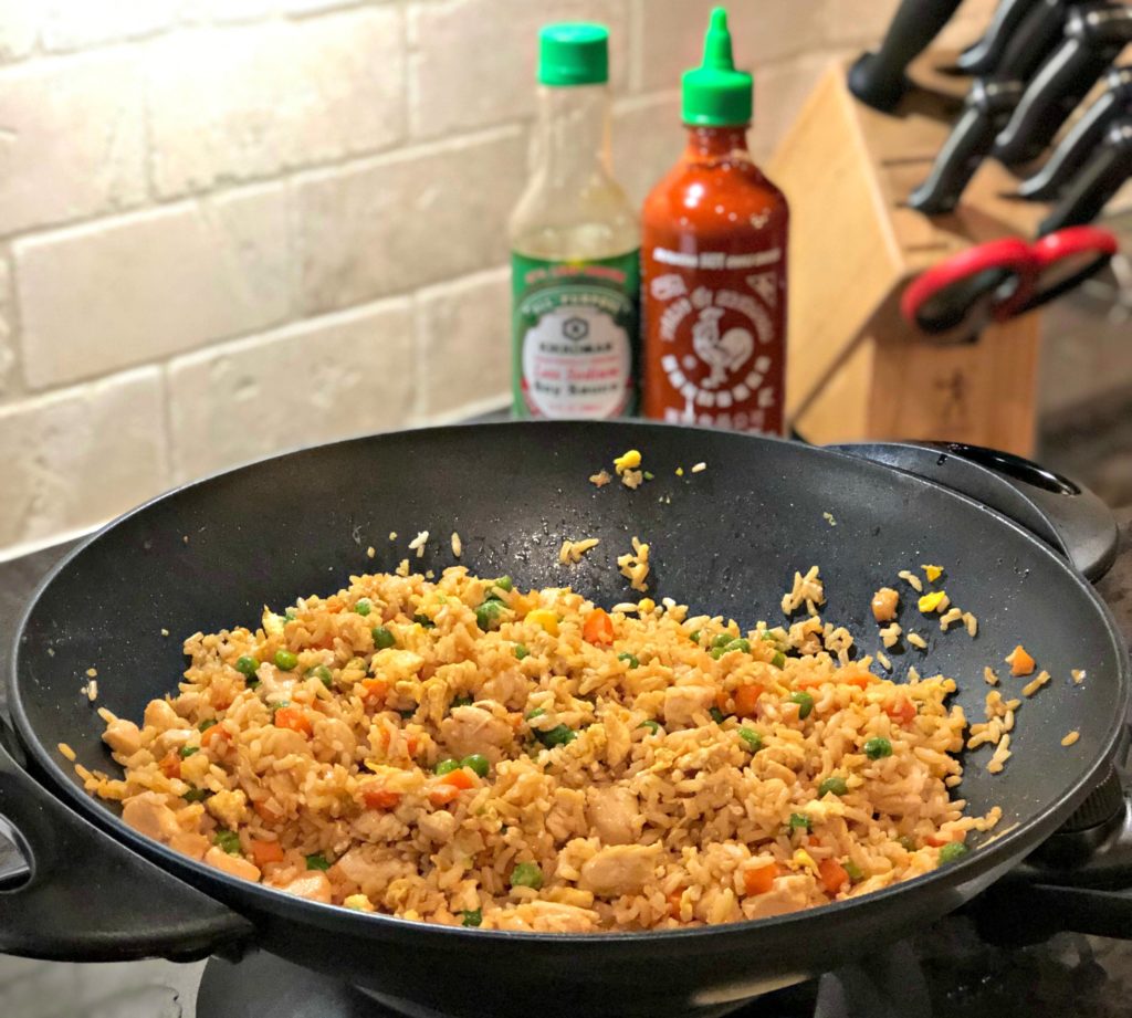 Chicken Fried Rice in a wok with Sriracha sauce