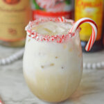 a creamy peppermint alcohol drink with a candy cane rim.