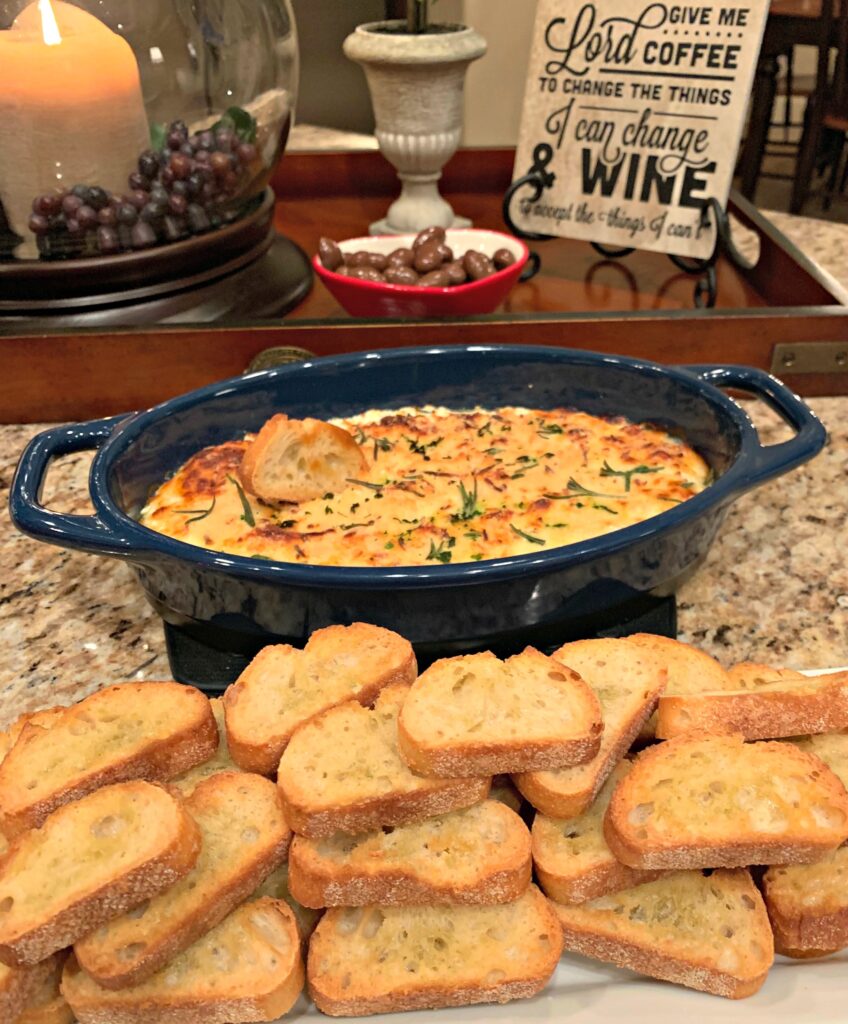 toasted baguette bread with a baking dish of creamy ricotta cheese dip.