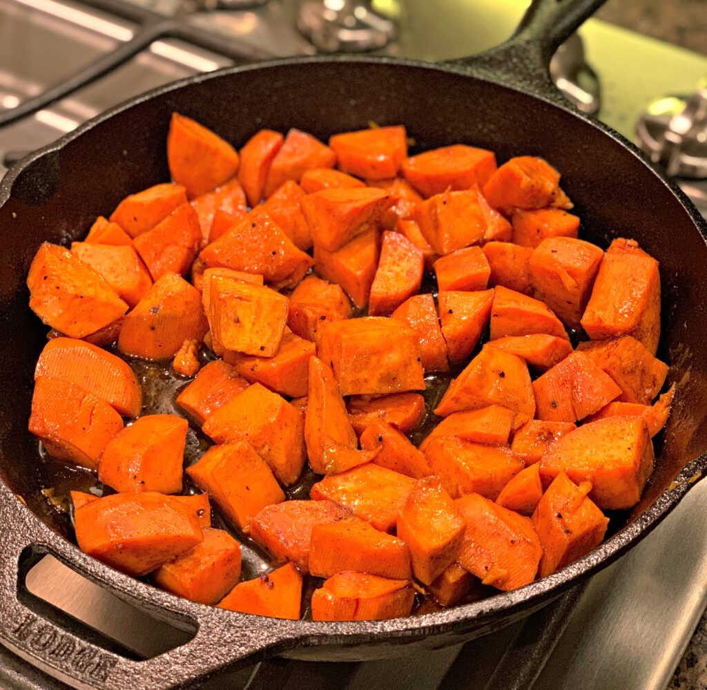 diced sweet potatoes coated in honey and cinnamon, then cooked in a cast iron skillet