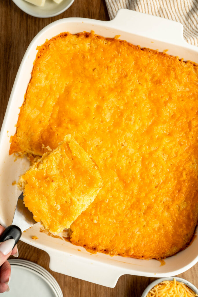 a piece of cornbread being scooped from a pan.