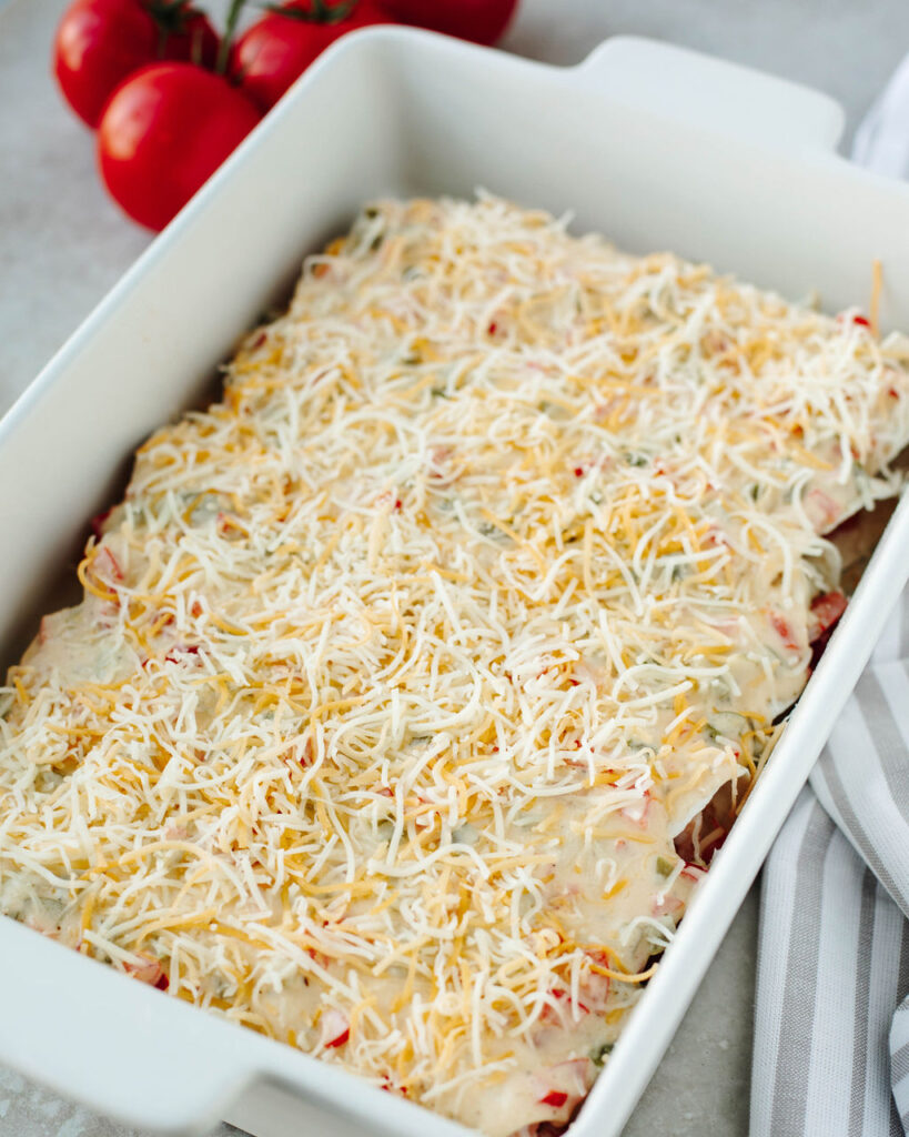 cheese topped enchiladas ready to bake in the oven.
