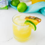 a lime and pineapple wedge on a glass filled of Hawaiian margaritas.