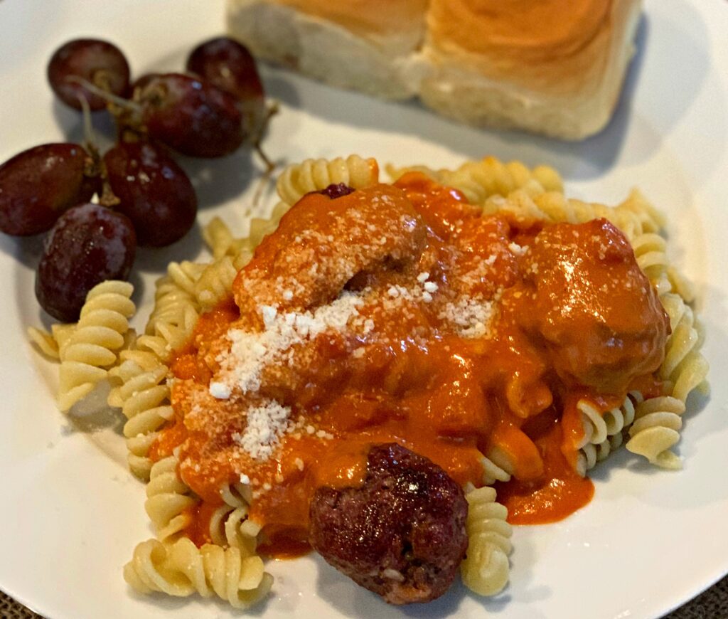 meatballs covered in pasta sauce and served over tender noodles