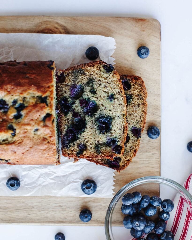 Blueberry Banana Bread sliced on a cutting board.