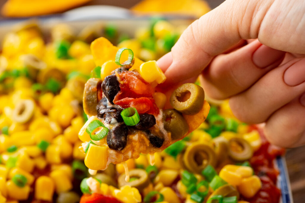 layers of beans, veggies, and seasoning in this tex mex dip