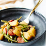 a serving of Instant Pot Sausage, Potatoes, and Green Beans on a dinner plate.