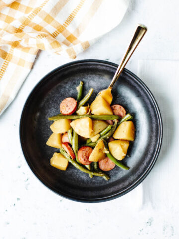 a plate of instant pot Cajun sausage, potatoes, and green beans.