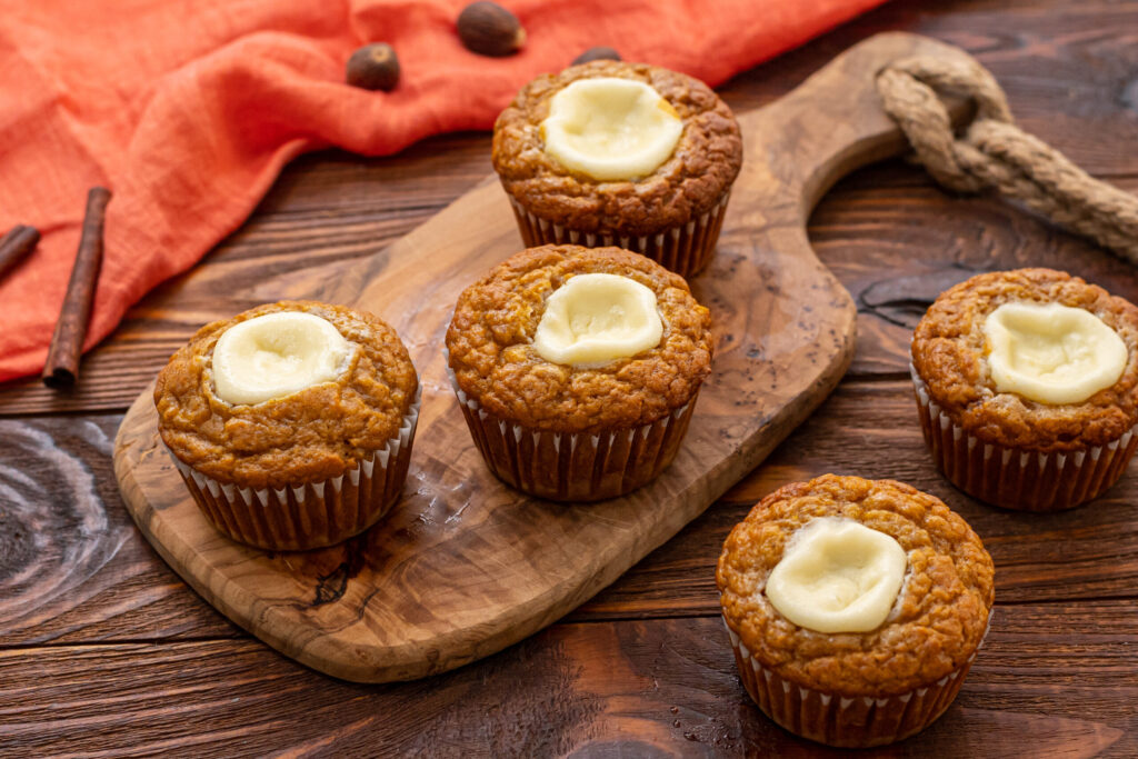 an assorted tray of pumpkin muffins with a creamy center cream cheese filling