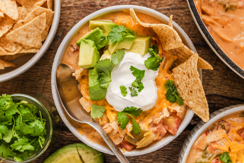 Sour cream, avocado, and chips served on top of Tex Mex soup.