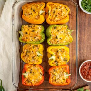 sliced peppers lined up in a baking pan ready for the oven