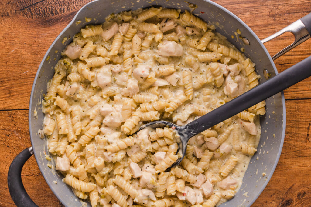 salsa verde chicken pasta cooked in a skillet and ready to serve.