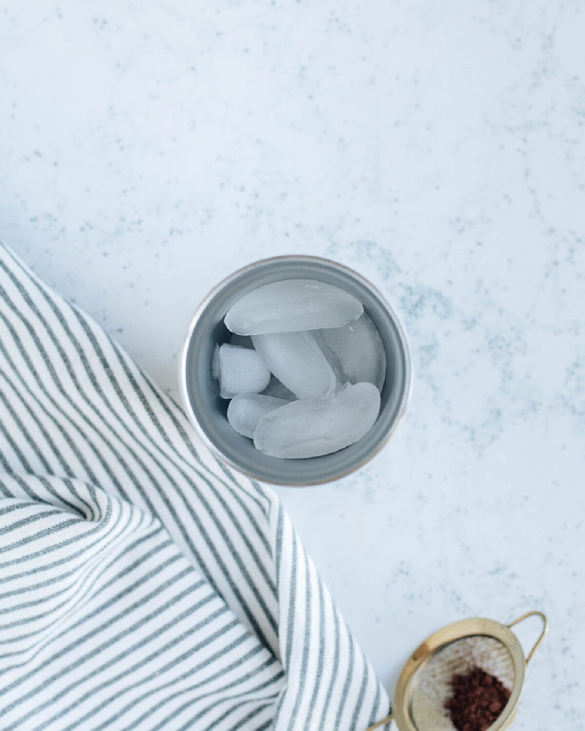 ice cubes added to a cocktail shaker.