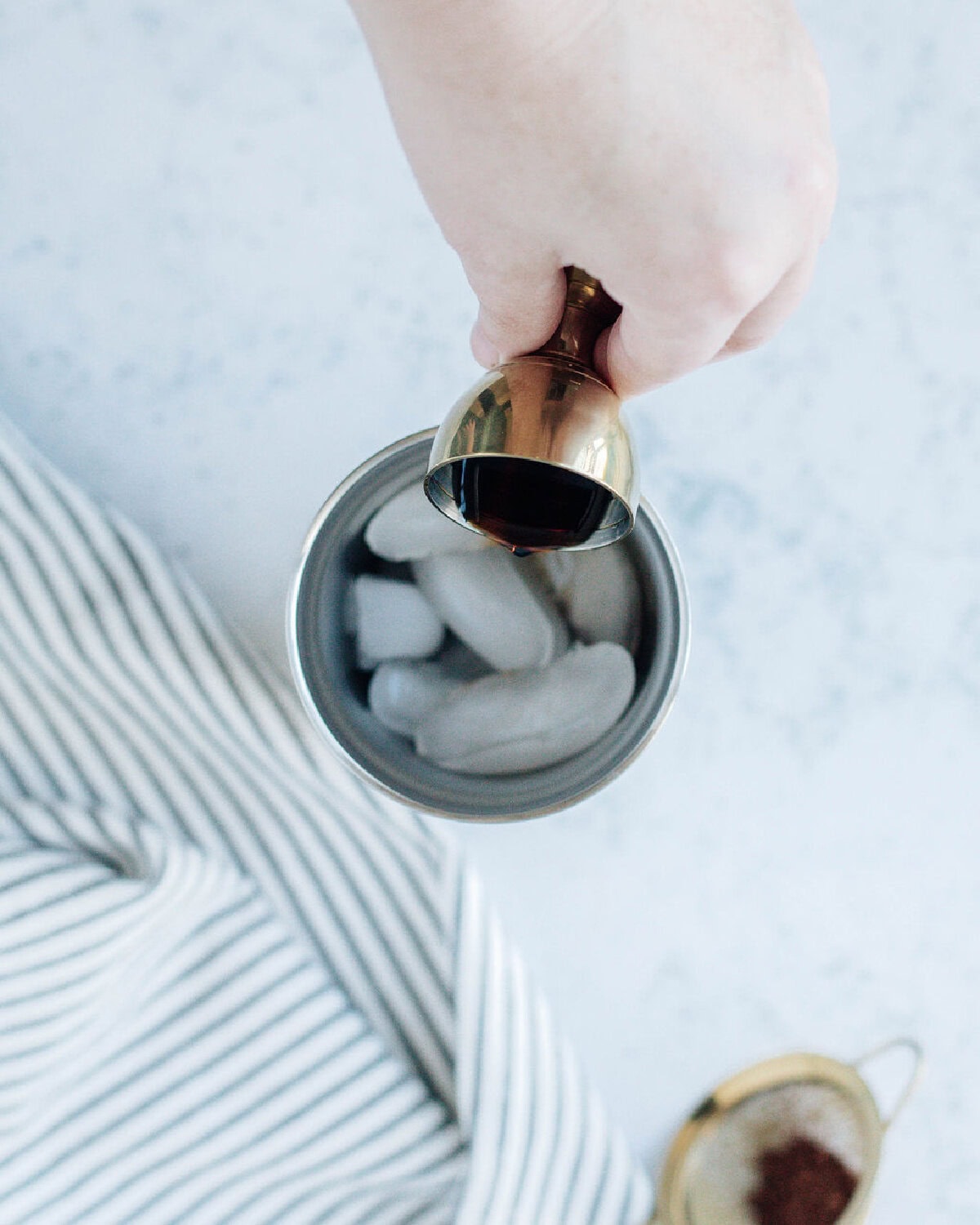 amaretto poured into a cocktail shaker with vodka and ice.