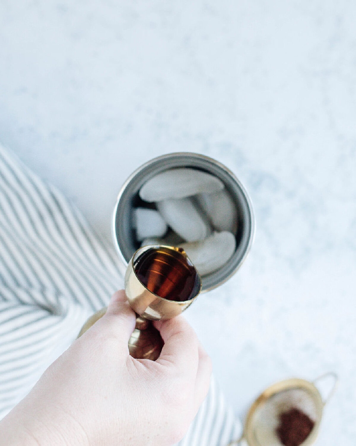 Kahlua added to a cocktail shaker with ice.