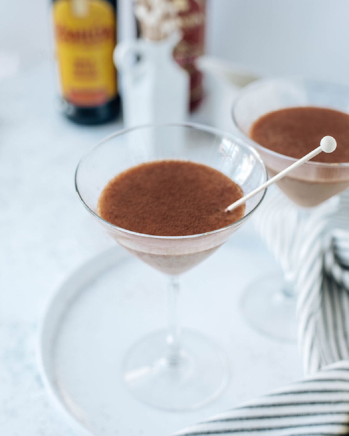 cocoa powder sprinkled on top of tiramisu martini's in a glass.
