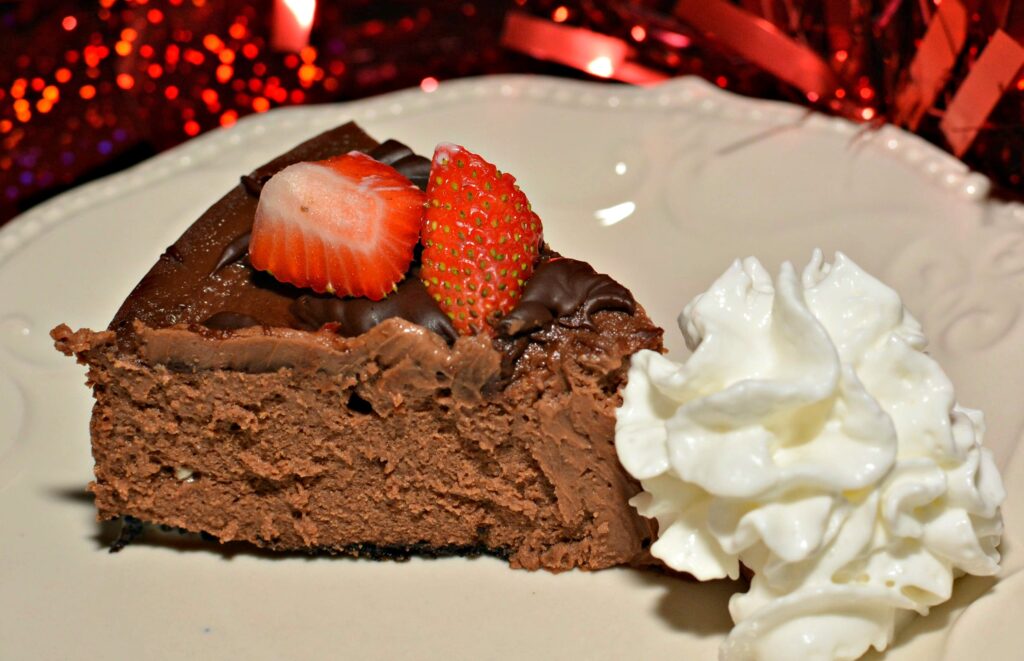 chocolate cheesecake with an oreo crumb crust and fresh strawberries on top