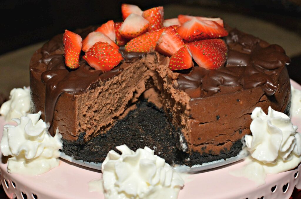 chocolate cheesecake with whipped cream and strawberries on top