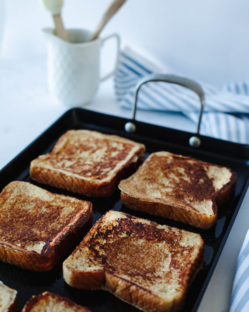 egg coated bread cooking on a griddle.