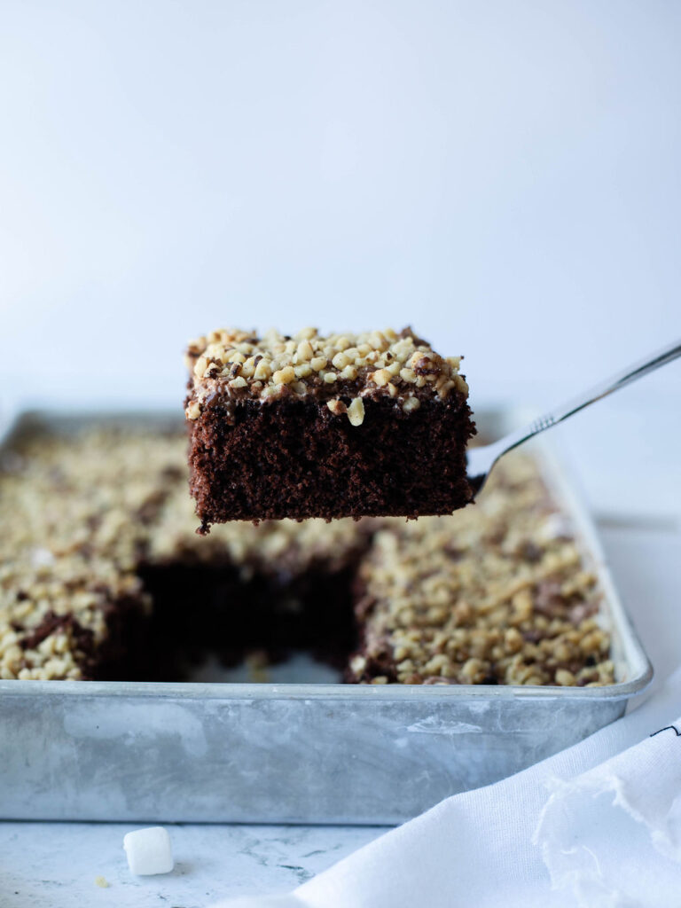 a piece of cake being removed from a 9x13 baking pan.