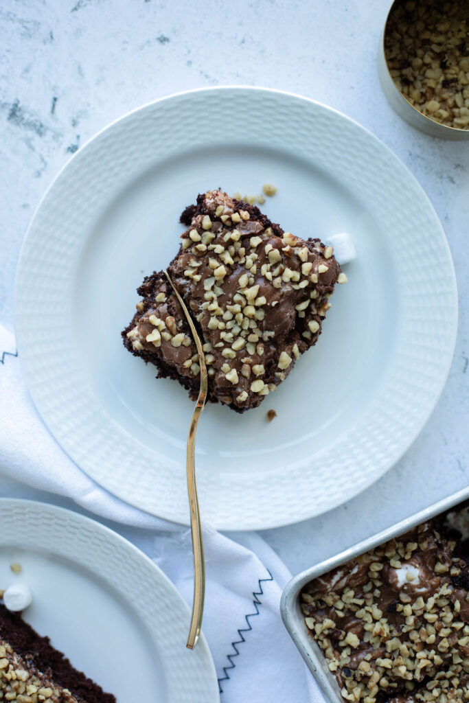 a piece of mississippi mud chocolate cake on a white dessert plate.