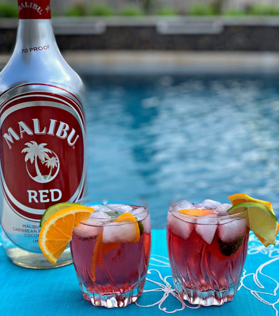 two cocktails lined up in front of a pool