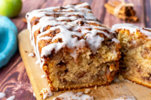 apple fritter quick bread with a white icing drizzled on top