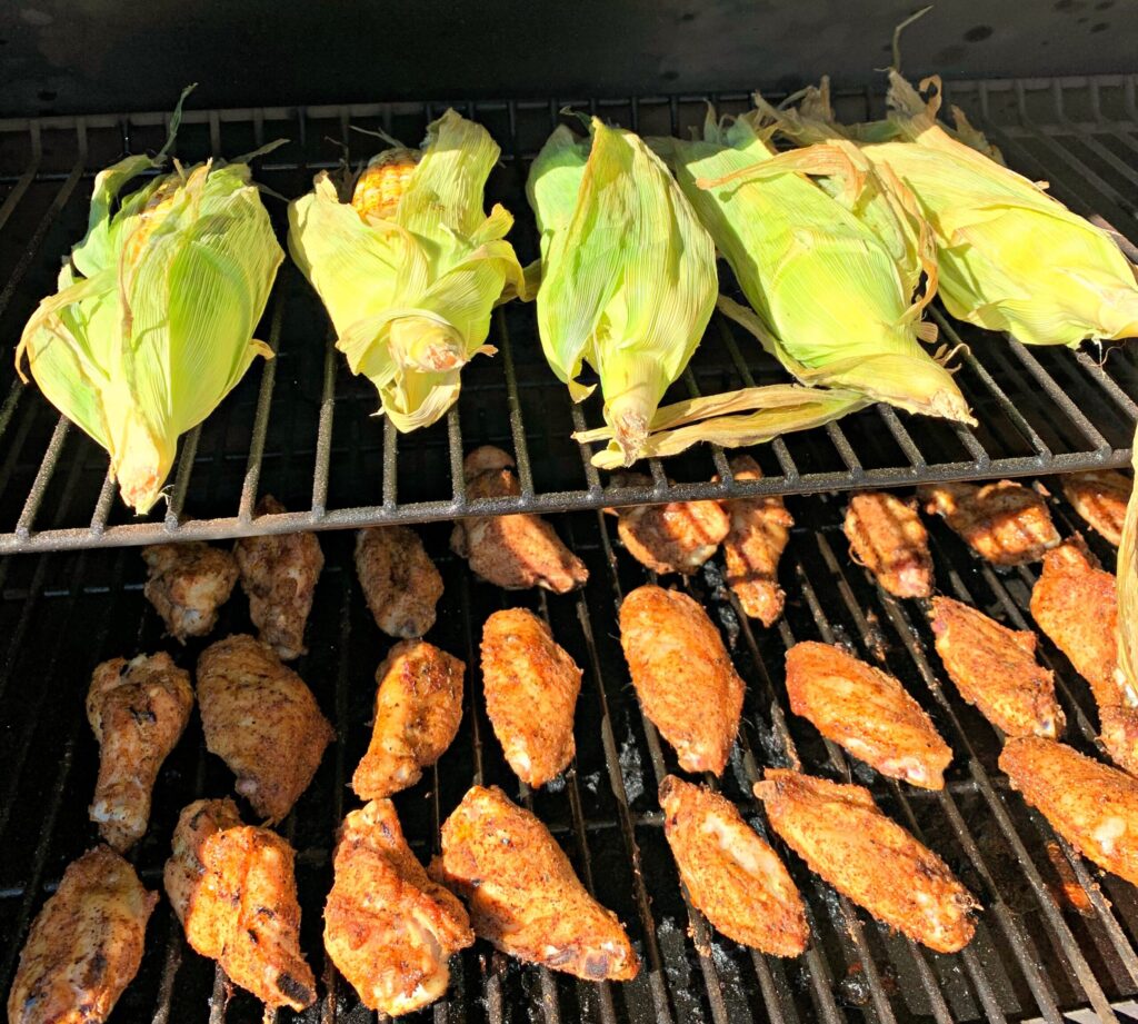 Sweet corn and chicken wings lined up on the smoker