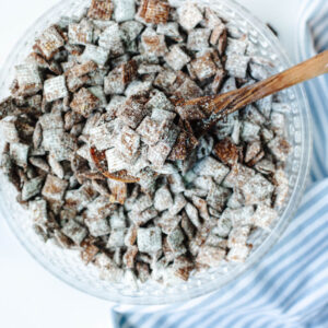 a glass bowl of chocolate peanut butter coated Corn Chex mix.