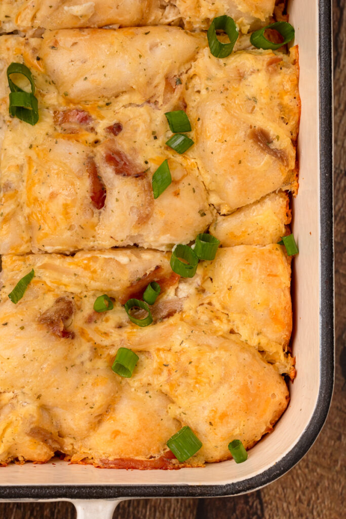 cooked chicken casserole with green onions and bacon on top.